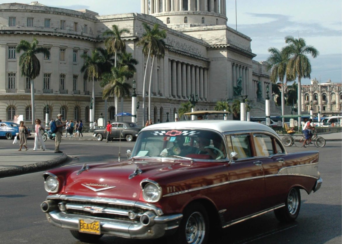 A Chevy cruises past the Capitolio building in Cuba