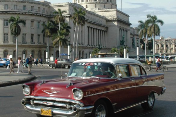 A Chevy cruises past the Capitolio building in Cuba