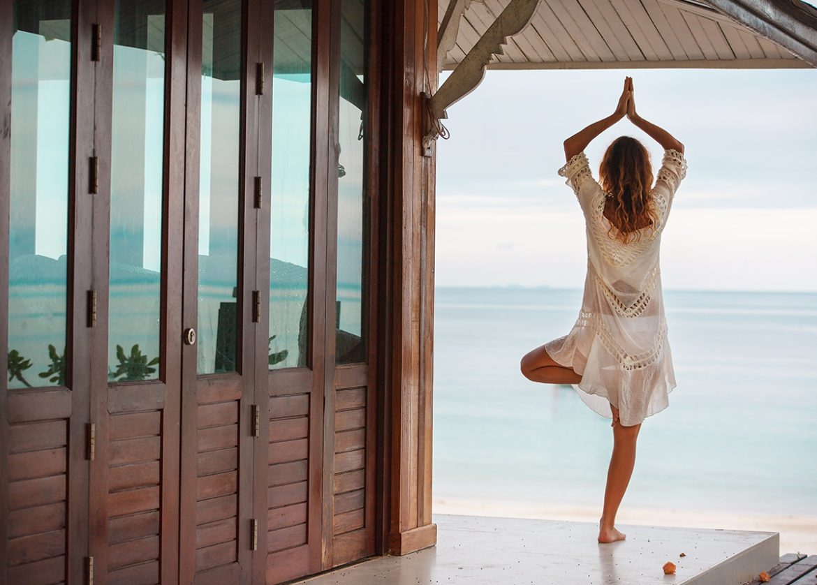 Woman practicing yoga on the beach