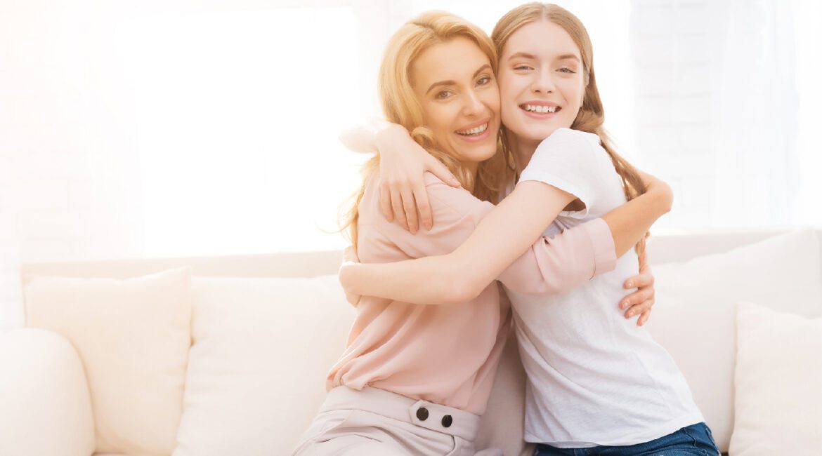 Mom,And,Teenage,Daughter,Embrace.,They,Are,Sitting,On,The